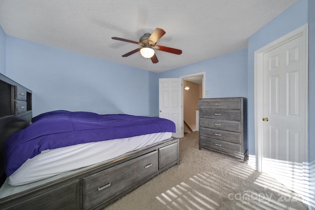 carpeted bedroom featuring a textured ceiling and ceiling fan