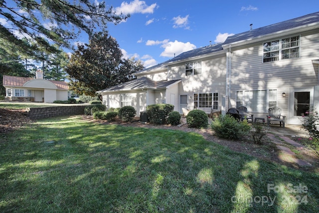 rear view of house with a patio area and a lawn