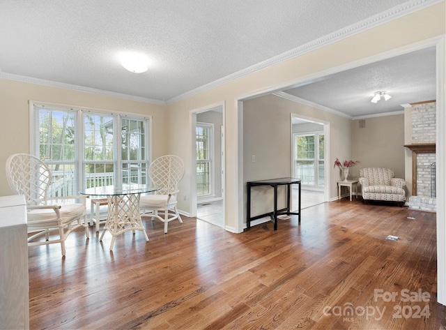 unfurnished dining area with hardwood / wood-style floors, a fireplace, and a textured ceiling