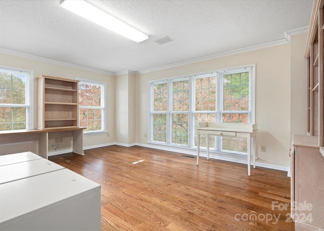 unfurnished office with hardwood / wood-style floors, ornamental molding, and a textured ceiling