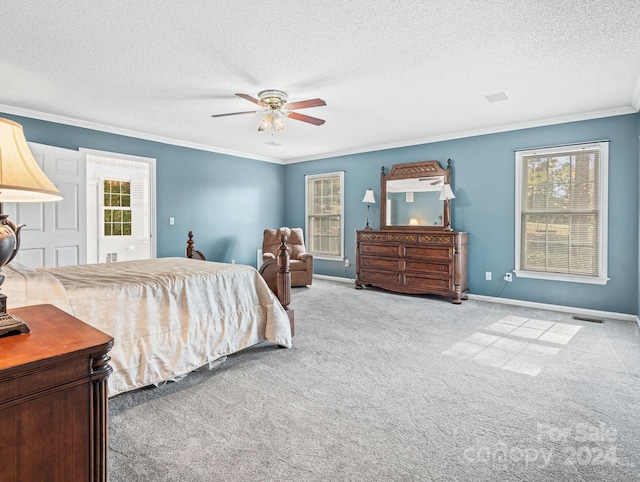 carpeted bedroom with ceiling fan, a textured ceiling, and ornamental molding