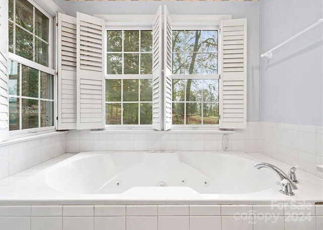 bathroom featuring tiled bath and plenty of natural light