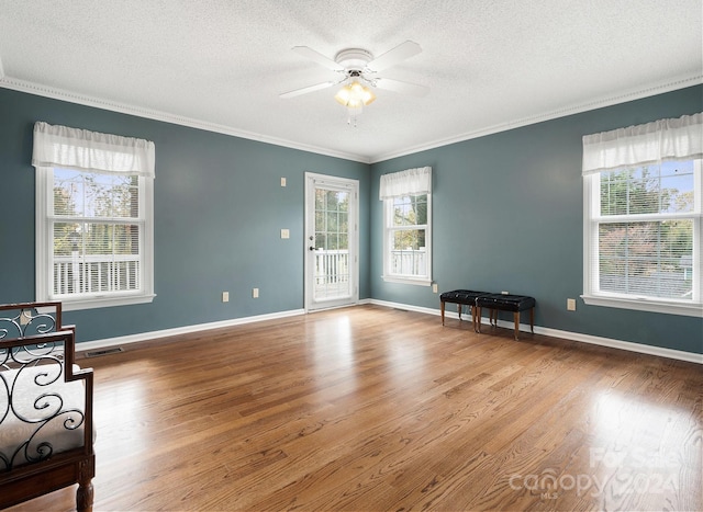 unfurnished room featuring a textured ceiling, hardwood / wood-style flooring, ceiling fan, and crown molding