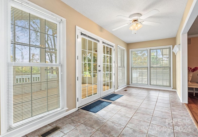 entryway with a textured ceiling, french doors, ceiling fan, and light tile patterned flooring