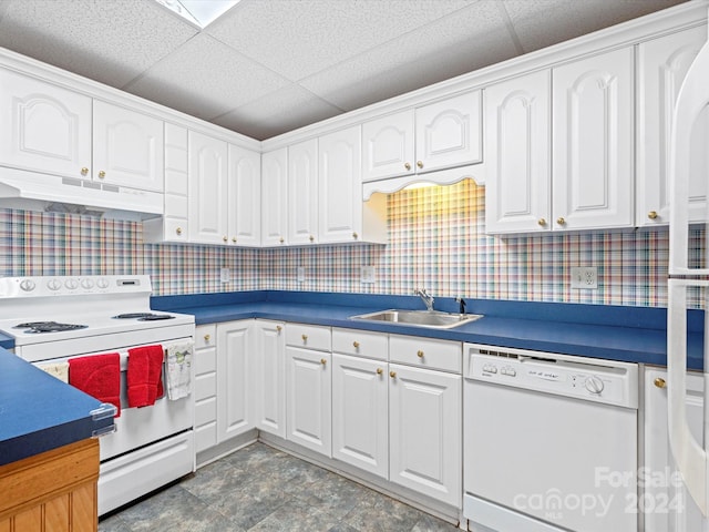 kitchen with white appliances, a drop ceiling, and white cabinets