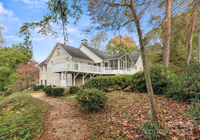 back of house featuring a sunroom and a wooden deck