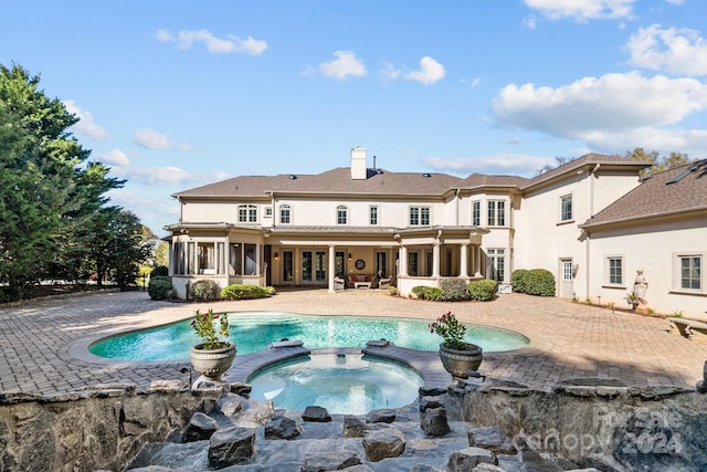 view of swimming pool featuring an in ground hot tub and a patio