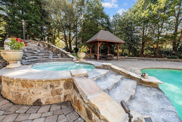 pool with a gazebo, a patio, fence, and an in ground hot tub