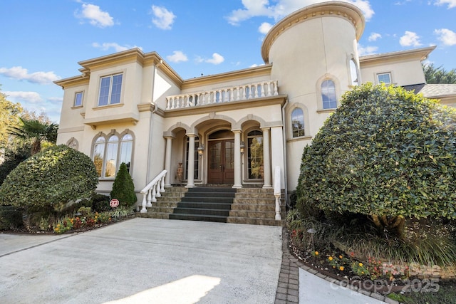 view of exterior entry featuring french doors and stucco siding