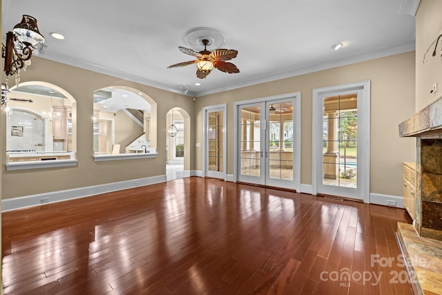 unfurnished living room with ceiling fan, baseboards, wood finished floors, and french doors