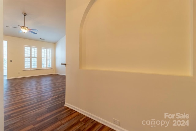 empty room with dark wood-type flooring, lofted ceiling, and ceiling fan