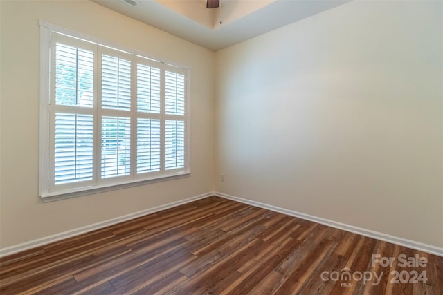 spare room with ceiling fan, dark wood-type flooring, and a wealth of natural light