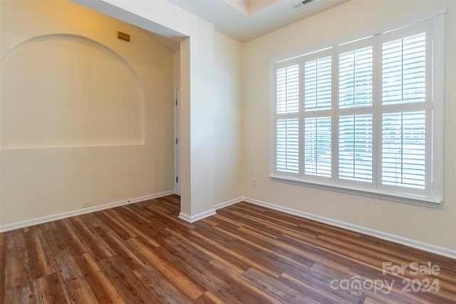 empty room featuring dark hardwood / wood-style flooring and a healthy amount of sunlight