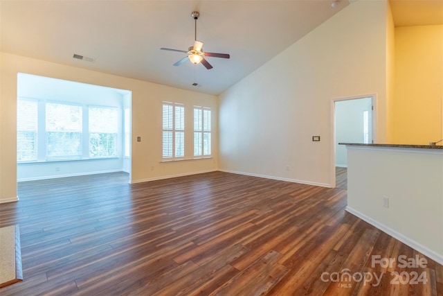 unfurnished living room featuring high vaulted ceiling, ceiling fan, and dark wood-type flooring