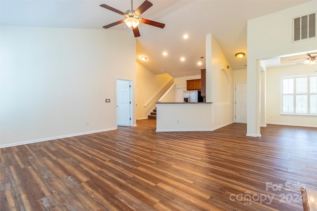 unfurnished living room with ceiling fan, dark hardwood / wood-style floors, and high vaulted ceiling