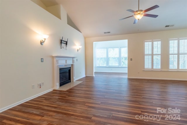 unfurnished living room featuring ceiling fan, dark wood-type flooring, a high end fireplace, and high vaulted ceiling