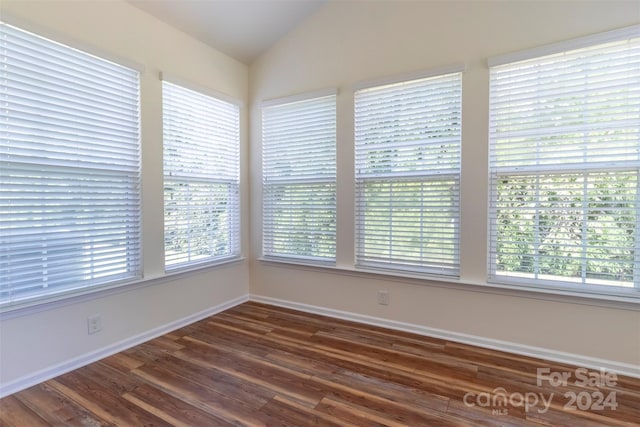 spare room with lofted ceiling and dark hardwood / wood-style flooring