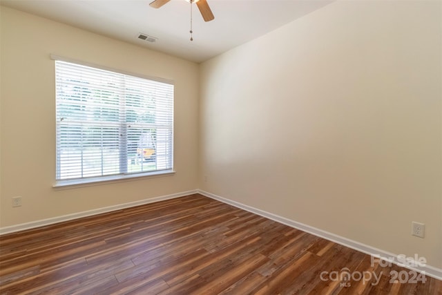 empty room with ceiling fan and dark hardwood / wood-style flooring