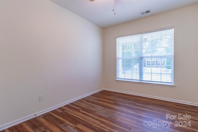 empty room with ceiling fan and dark hardwood / wood-style floors