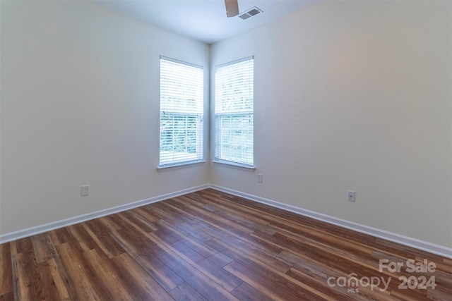 spare room with ceiling fan, plenty of natural light, and dark wood-type flooring