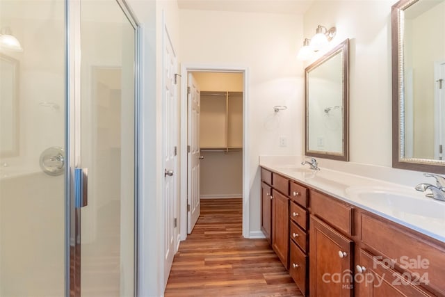 bathroom with walk in shower, hardwood / wood-style flooring, and vanity