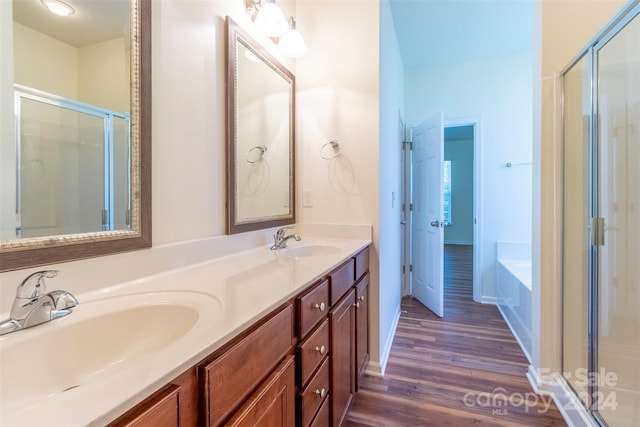 bathroom featuring independent shower and bath, vanity, and wood-type flooring