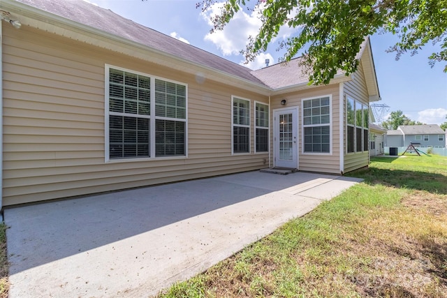 back of property with a yard and a patio