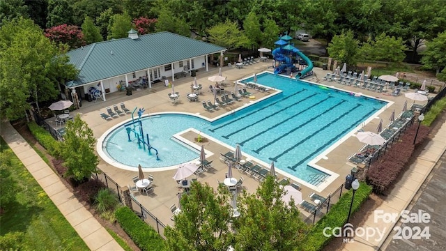 view of pool featuring a water slide and a patio area