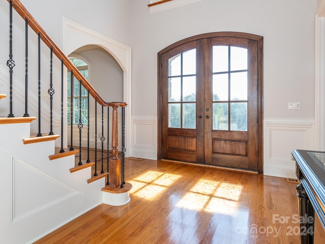 entrance foyer with french doors and light hardwood / wood-style floors