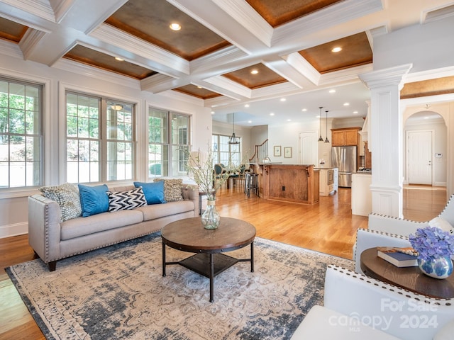 living room featuring beamed ceiling, ornamental molding, coffered ceiling, and light hardwood / wood-style floors