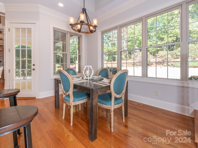 dining area with ornamental molding, a healthy amount of sunlight, and light wood-type flooring