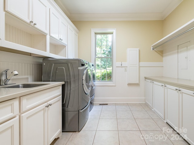 washroom featuring sink, light tile patterned flooring, crown molding, and cabinets