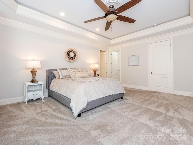 bedroom with ceiling fan, crown molding, a tray ceiling, and light carpet