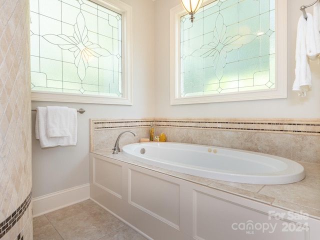 bathroom with a bathtub, a healthy amount of sunlight, and tile patterned flooring