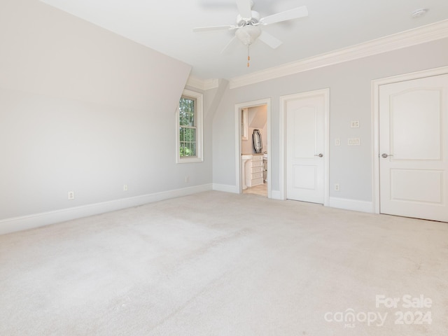 unfurnished bedroom with ornamental molding, ensuite bathroom, light colored carpet, and ceiling fan