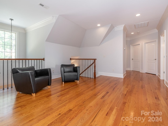 sitting room featuring a notable chandelier, ornamental molding, and light wood-type flooring