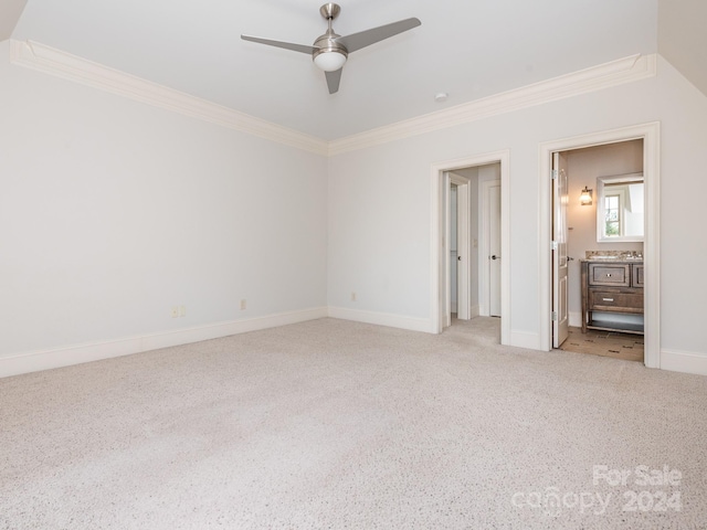 unfurnished bedroom featuring ensuite bath, light carpet, crown molding, and ceiling fan