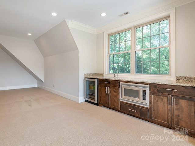 bar featuring wine cooler, dark brown cabinetry, light carpet, and stainless steel microwave