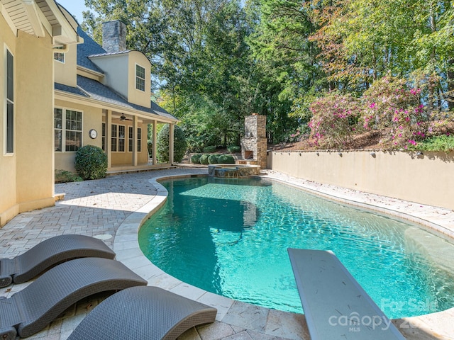 view of pool featuring a patio, an in ground hot tub, and a diving board