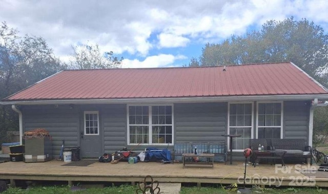 back of property featuring an outdoor hangout area and a deck