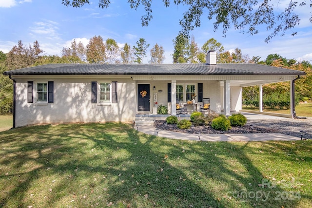 ranch-style house featuring a front yard, covered porch, and a carport