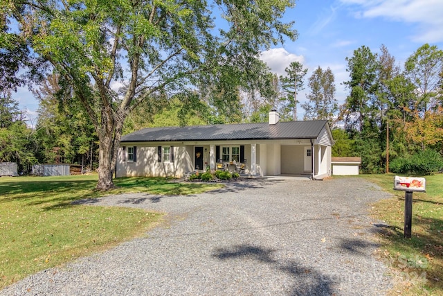 single story home with a front lawn, covered porch, and a garage