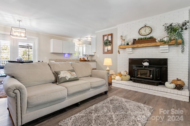 living room featuring crown molding, brick wall, a chandelier, and dark hardwood / wood-style floors