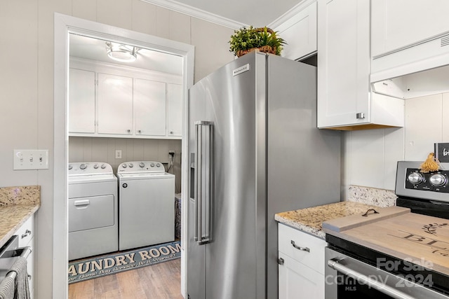 kitchen with white cabinetry, separate washer and dryer, light hardwood / wood-style flooring, ornamental molding, and stainless steel appliances