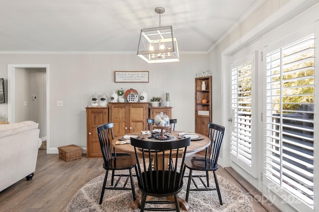 dining area with light hardwood / wood-style floors and ornamental molding