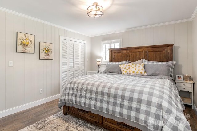 bedroom with ornamental molding, wooden walls, wood-type flooring, and a closet