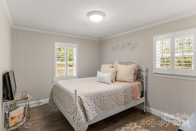 bedroom featuring crown molding, wooden walls, and dark hardwood / wood-style floors