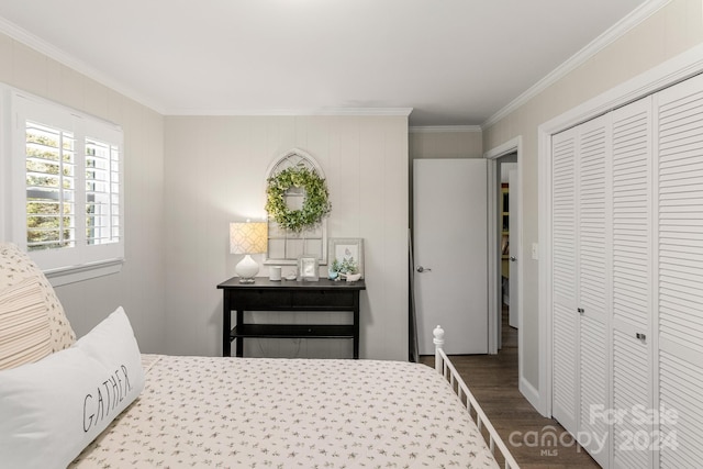 bedroom with a closet, crown molding, and hardwood / wood-style floors