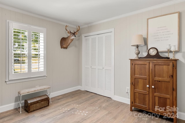 bedroom with a closet, crown molding, and light wood-type flooring