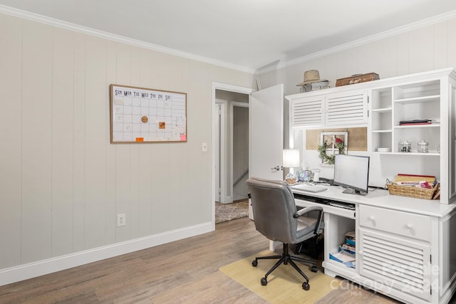 office with light hardwood / wood-style flooring, wooden walls, and crown molding